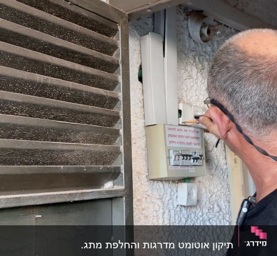 חשמלאי בודק לוח חשמל עם מפסקים